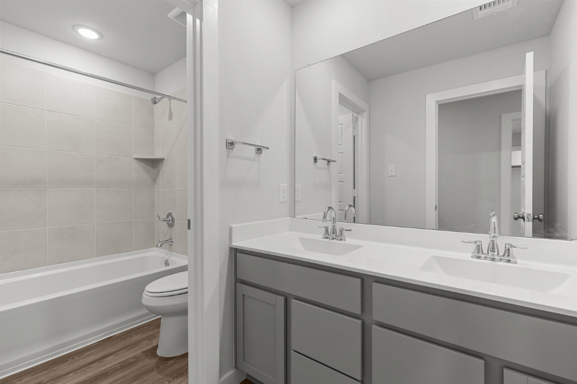A bathroom with a tub sink and toilet.