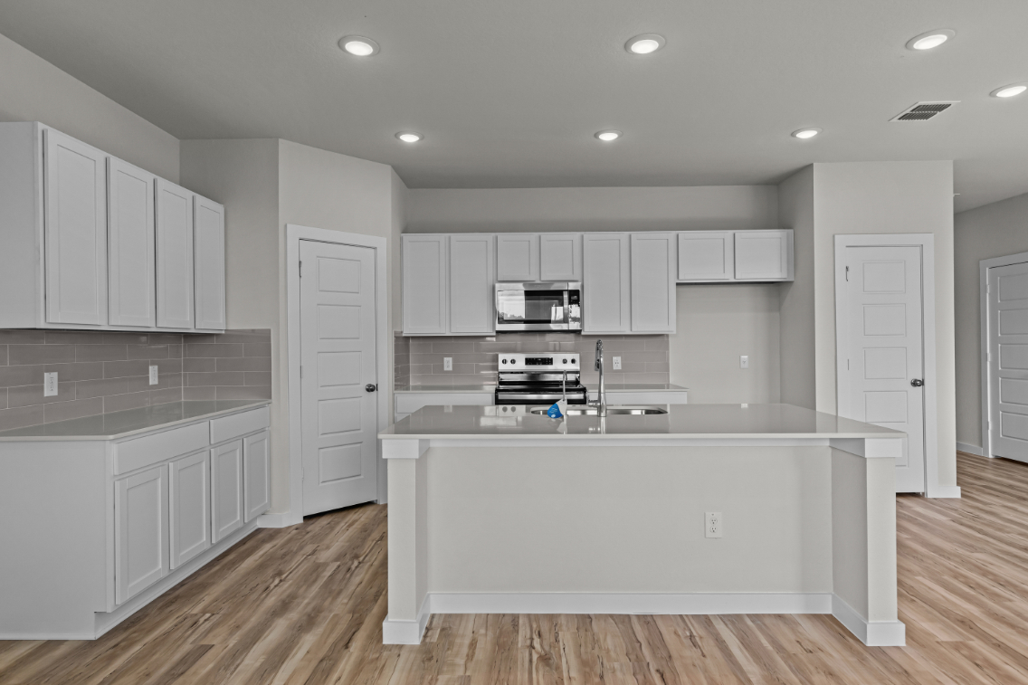 A kitchen with white cabinets.