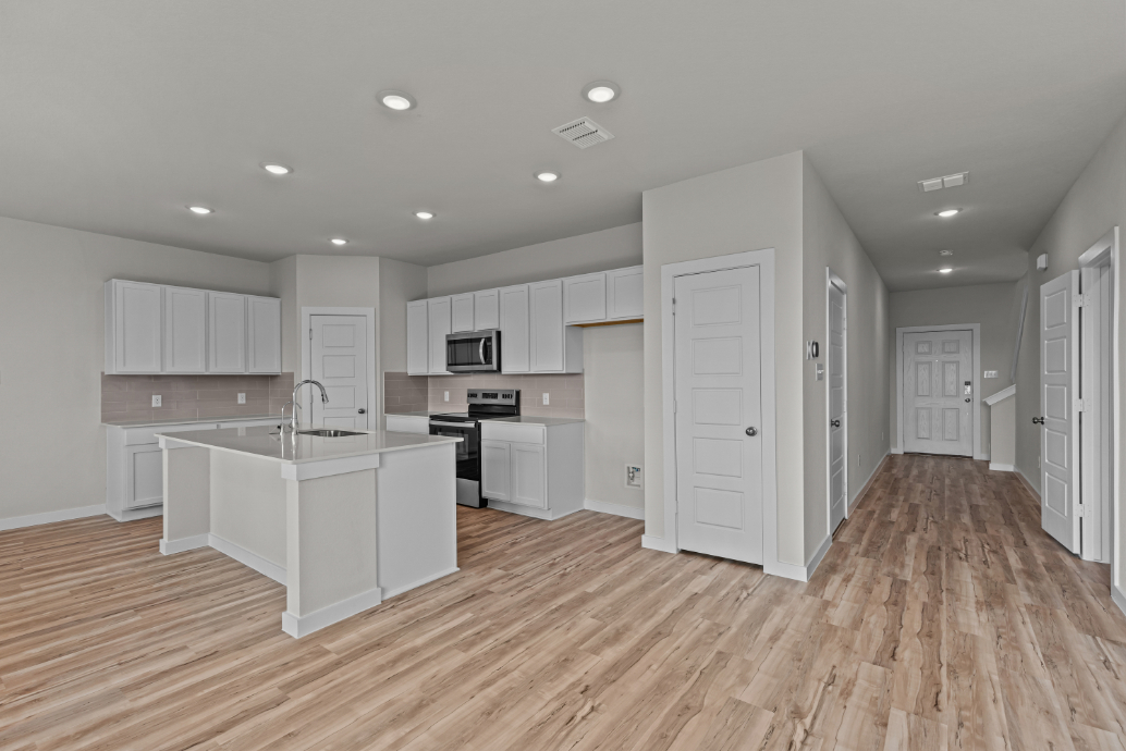 A kitchen with white cabinets.