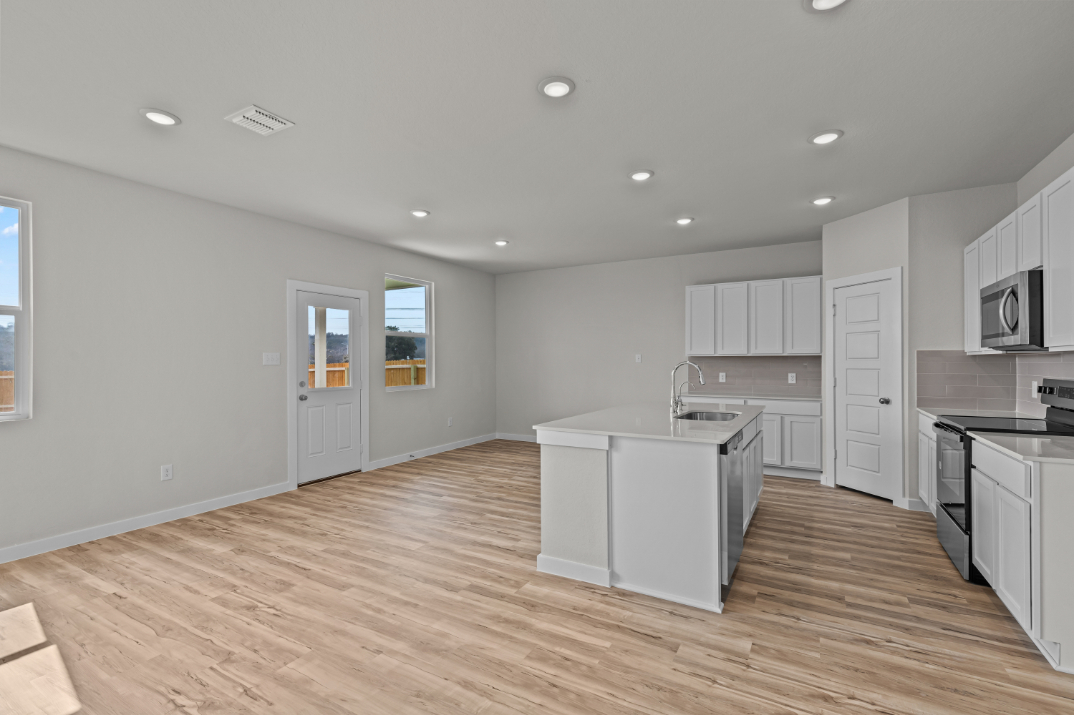A kitchen with white cabinets.