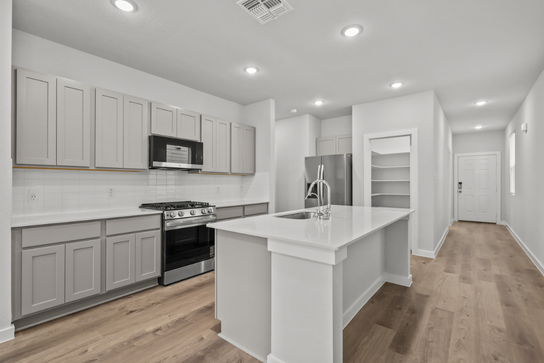 A kitchen with white cabinets.