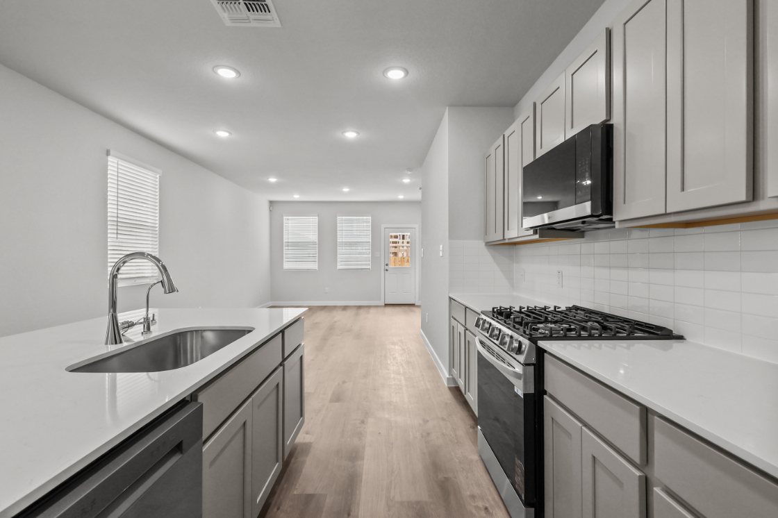 A kitchen with white cabinets.