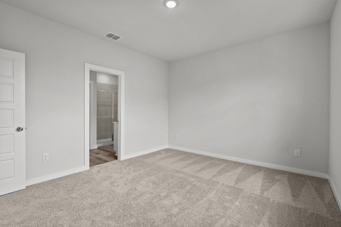A room with a carpet and a door.