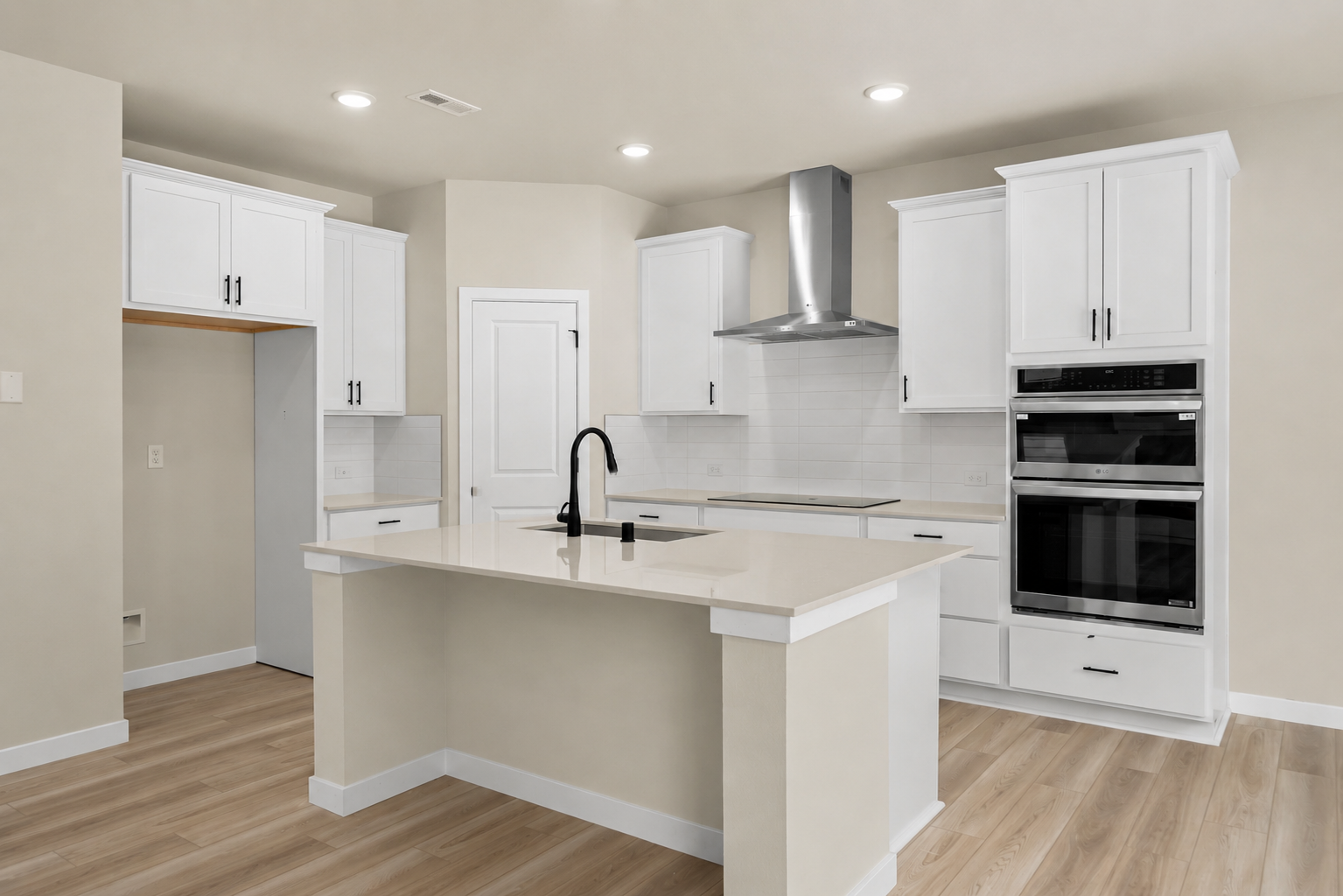 A kitchen with white cabinets.