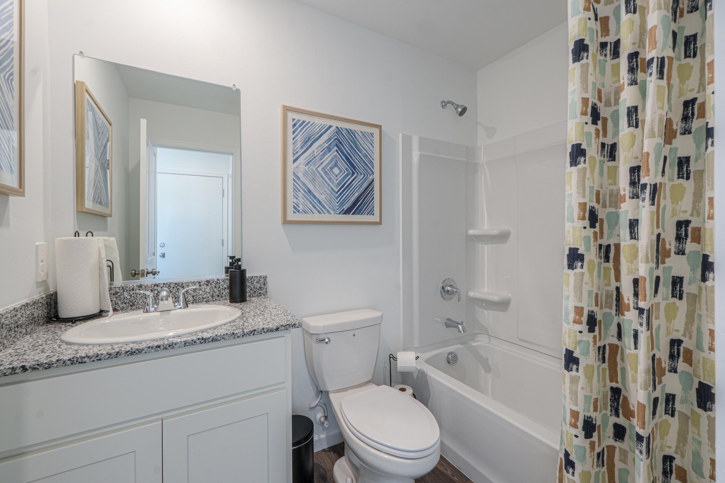 A bathroom with a sink toilet and bathtub.