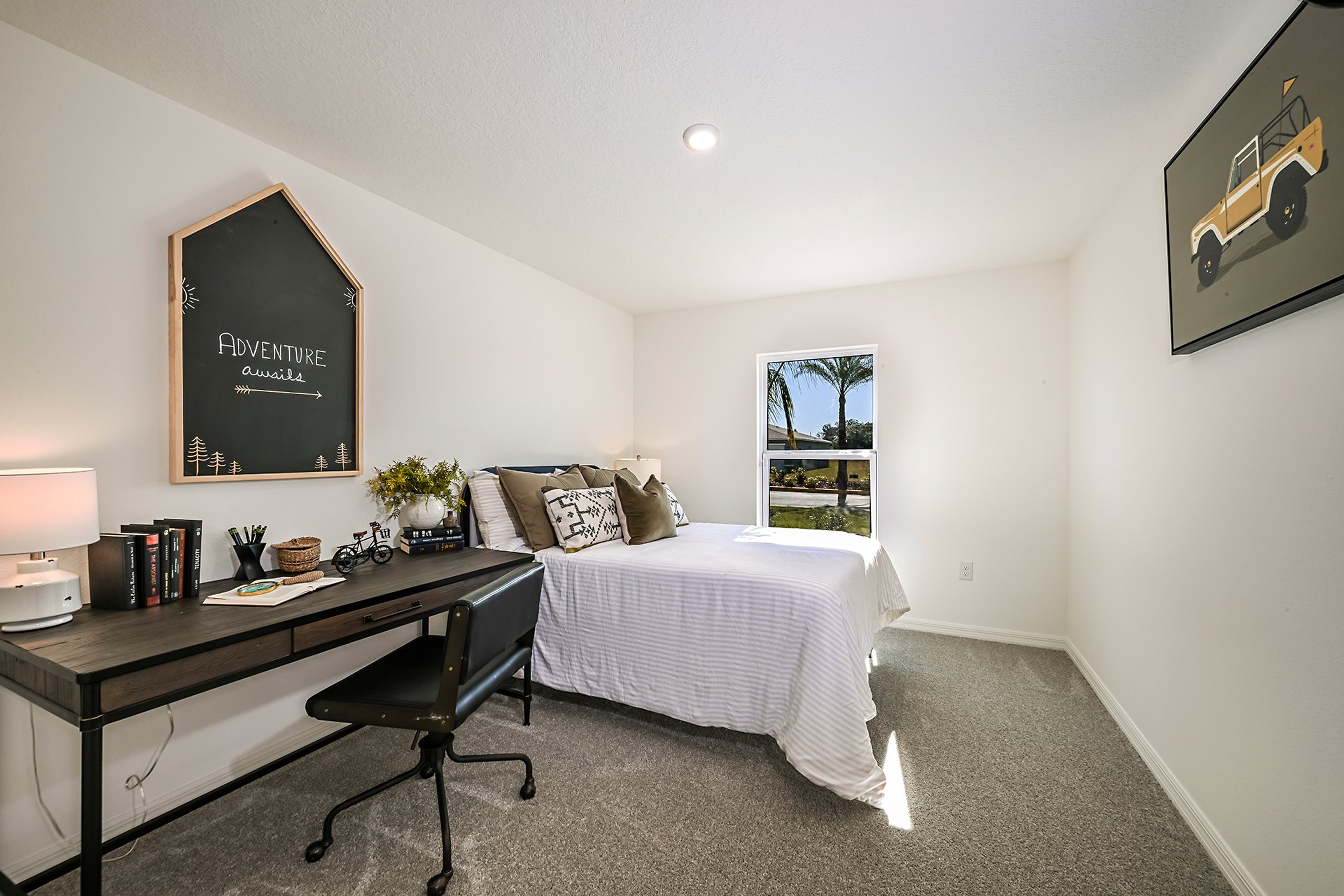 A bedroom with a bed desk and chair.