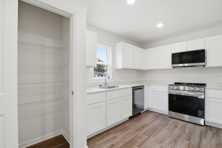A kitchen with white cabinets.