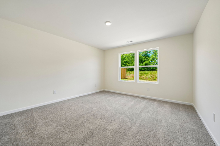 A room with a window and a carpet.