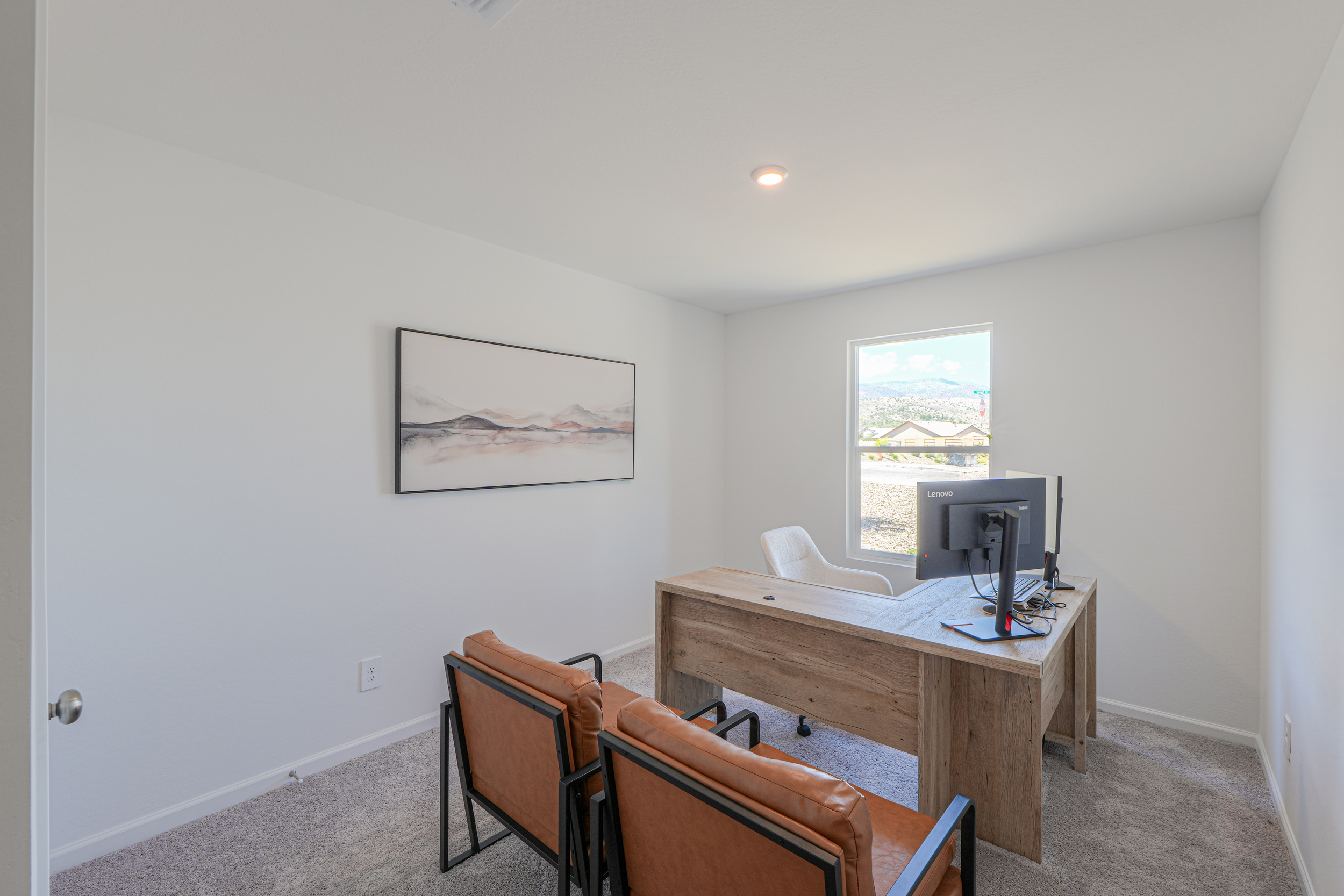 A room with a desk and chairs.