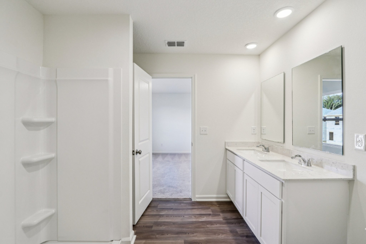 A bathroom with white cabinets.