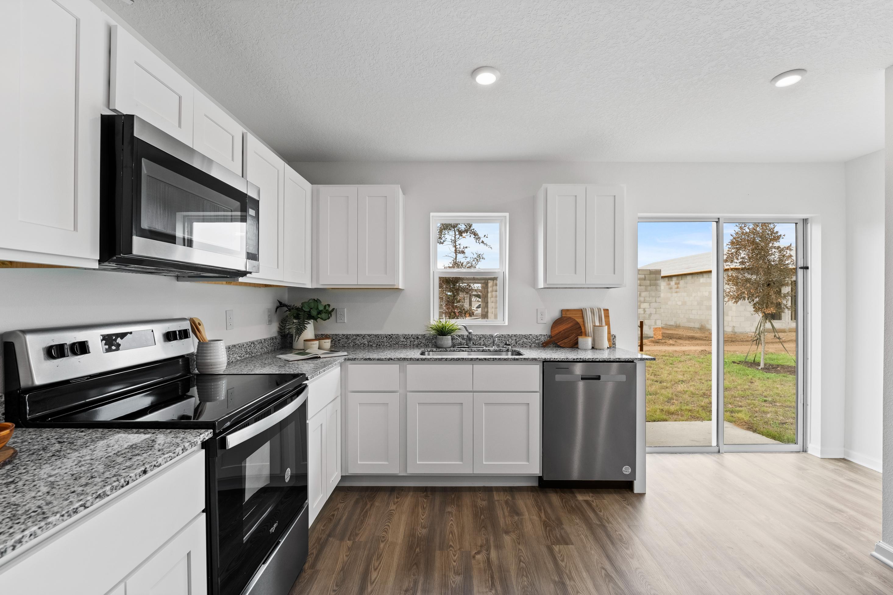 A kitchen with white cabinets.
