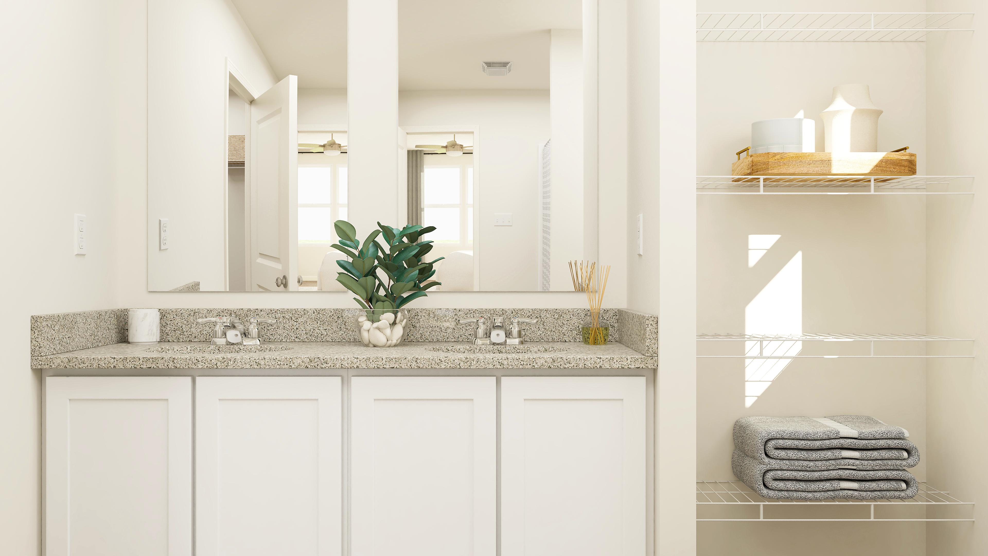 A bathroom with white cabinets.